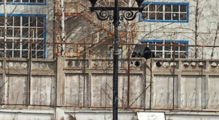 На изображении представлена парковая опора, украшенная в верхней части кронштейном модели «Пушкинский». Такие инженерные конструкции используются для устройства освещения в городских парках и скверах. На кронштейне установлены торшерные СП с рассеивателем в форме веретена.